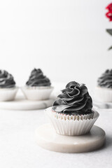 grey frosting on cupcakes with a white background, cupcakes in white liners with tall buttercream swirl, grey buttercream frosted cupcakes on a white background