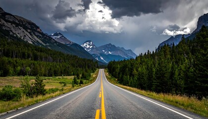 Long, straight highway road stretching toward snow-capped mountains under a cloudy, dramatic sky