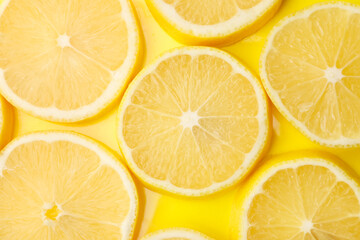 Slices of fresh lemon on yellow background, flat lay