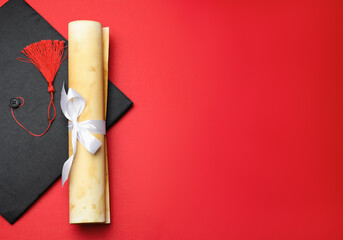 Diploma and graduation hat on red background, top view. Space for text