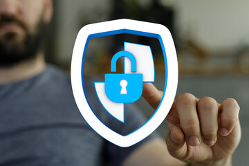 A man's hand interacts with a digital shield icon featuring a padlock, symbolizing data protection, security, and online safety. The