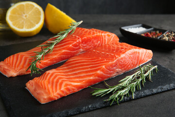 Pieces of salmon fillet and spices on grey table, closeup