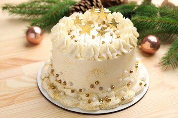 Delicious cake with Christmas decor on light wooden table, closeup