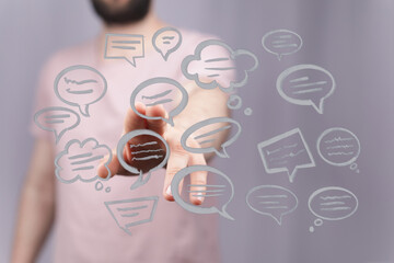 Person interacts with digital speech bubbles, symbolizing modern communication and technological interfaces. Focus on connection.
