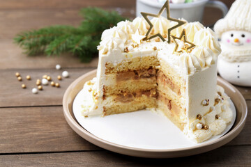 Delicious cake with Christmas decor on wooden table, closeup. Space for text