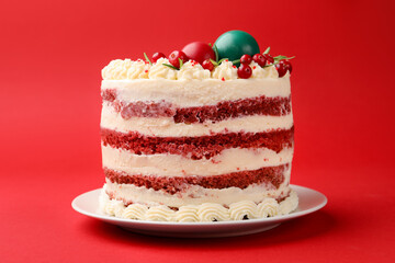 Delicious sponge cake with Christmas decor and berries on red background, closeup