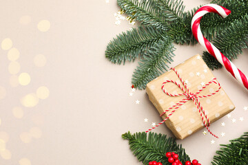 Fir tree branches, gift and Christmas decor on light background, flat lay with bokeh effect. Space...