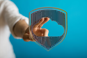 Concept of cloud security represented by hand holding a shield with cloud inside, perfect for data...