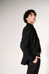 Obraz premium Stylish young man exudes confidence in modern black attire on a minimalist background