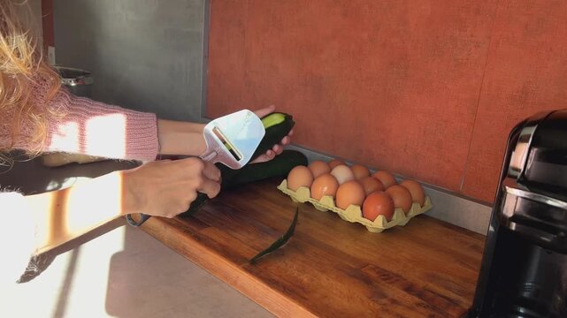Mujer pelando un calabac&iacute;n en la cocina, lifestyle