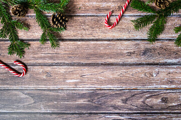 Arrière plan Noël - sucre d'orge - branche de sapins - pomme de pin - planche de bois brut