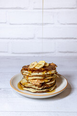Pile de pancakes avec des bananes et du sirop d'érable - petit déjeuner ou gouter plein de douceur