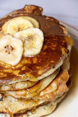 Pile de pancakes avec des bananes et du sirop d'érable - petit déjeuner ou gouter plein de douceur