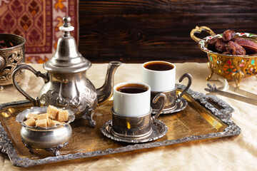 cup of coffee and vintage coffeepot on wooden table.
