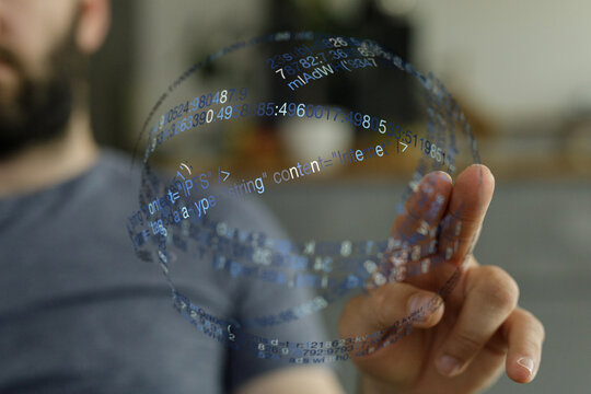 A close-up shot showing a person interacting with a virtual data sphere. A representation of code, future technology, and the digital