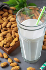 A delightful display of natural ingredients, featuring creamy almond milk in vessels alongside a generous pile of roasted almonds