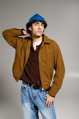 Young stylish man showcases modern fashion with cool confidence in a creative studio setting