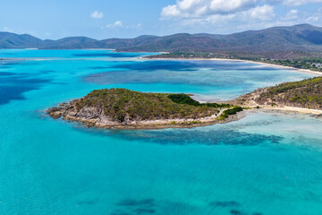 A breathtaking aerial view of Hydeaway Bay on Queensland’s Whitsunday Coast. The turquoise waters, white sandy beaches, and lush tropical landscape create a serene coastal paradise.
