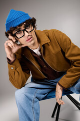 Stylish young man showcasing unique fashion sense in modern studio setting