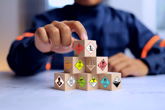 dangerous goods concept with safety staff arrange wooden block for hazardous substance warning sign to manage in storage area
