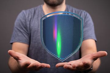 Man holding a glowing shield, representing digital protection, cybersecurity, and data defense....
