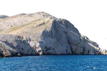 Rocky coastal cliff overlooking blue ocean water. Isolated object