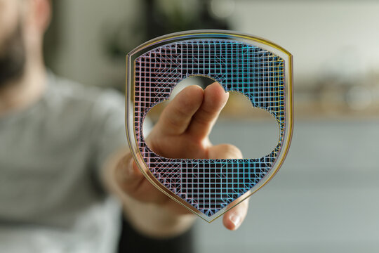 Abstract image representing cloud computing security and data protection. A hand gently touches a shield with a cloud shape, symboliz