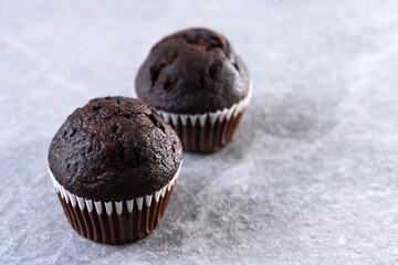 Homemade chocolate muffins on gray stone