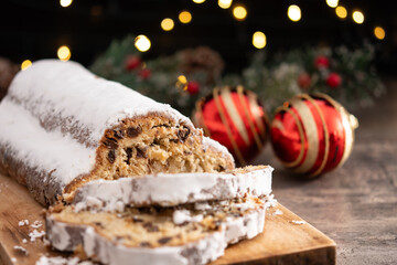 Traditional Christmas Stollen with Raisins and Powdered Sugar on christmas atmosphere background