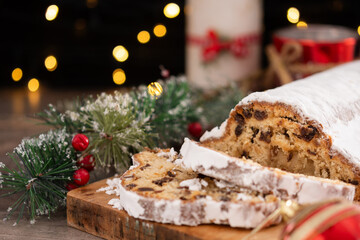 Traditional Christmas Stollen with Raisins and Powdered Sugar on christmas atmosphere background