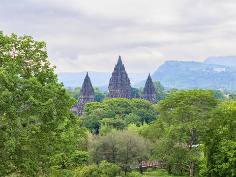 Aerial view of the majestic Prambanan Temple piercing through a sea of verdant foliage under a soft, overcast sky, Yogyakarta, Daerah Istimewa Yogyakarta, Indonesia.