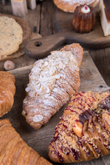 Various types of desserts and pastries on an old wooden background