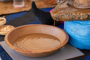 Fototapeta premium Traditional argan oil extraction from Essaouira, Morocco. Argan oil extraction by traditional stone handmill. Processing argan seeds, Product of Morocco.