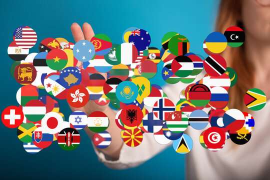 A hand holds a collection of diverse world flags, representing international unity, global cooperation, and the spirit of peace and friendship b