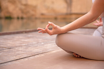 close up of woman hand practice yoga meditation in lotus position in nature