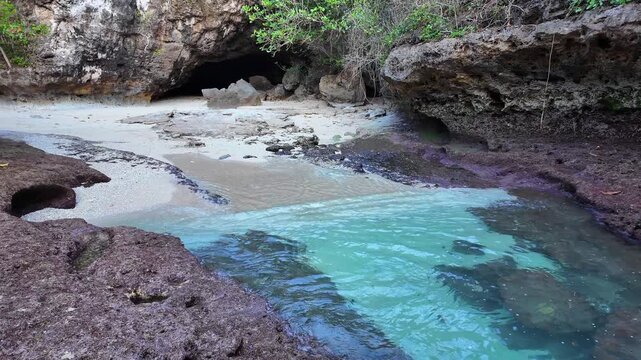 scene of waves filling rocky cave showcases Indonesia coastal landscape, highlighting mesmerizing dynamics of ocean tides and serene beauty, slow motion