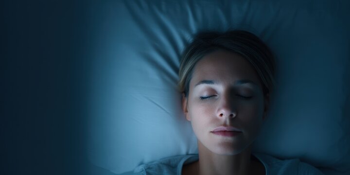 depression fatigue darkness concept. A woman peacefully sleeping in a darkened room.