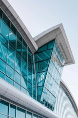 Obraz premium Futuristic airport terminal with angular glass facade and steel structure against clear sky, concept of advanced infrastructure, modern architecture and global connectivity