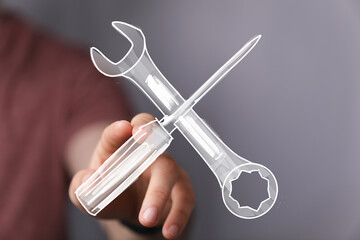 Hand holding digital sketch of wrench and screwdriver. Repair, maintenance, solution concept.