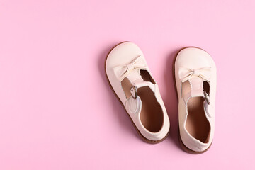 Pair of stylish kid's shoes on pink background, flat lay. Space for text
