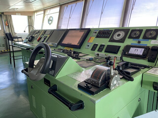 Fototapeta premium Navigation bridge of cargo ship with radar, ECDIS, engine telegraph, and control panels for safety systems. coke pit, of the big cargo ship.