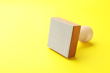 One wooden stamp on yellow background, closeup. Space for text