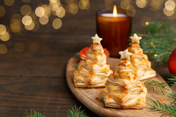 Christmas trees made with puff pastry, red caviar and festive decor on wooden table, closeup. Space for text