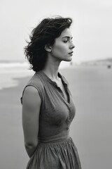 A woman standing on a beach next to the ocean