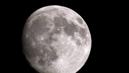 Detailed close-up video of the full moon filmed through a vintage MTO 1000A lens, showing visible craters and lunar maria in high contrast against the black night sky. - Powered by Adobe