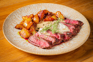 Tender steak with juicy, pink center served alongside crispy, caramelized potatoes