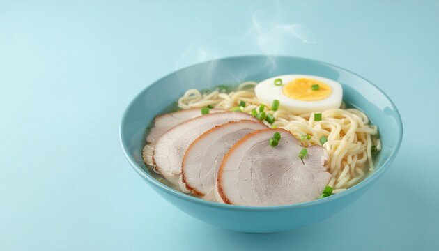 A steaming bowl of delicious ramen noodle soup, garnished with sliced pork, a soft-boiled egg, and fresh chives, served in a blue ceramic bowl on a pastel blue background