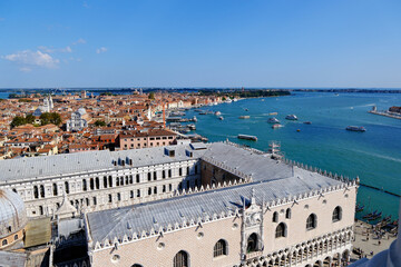 high angle aerial view of Doge's Palace roof, rooftops of Venice, and lagoon with boats