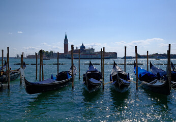 Moored gondolas on emerald lagoon water in Venice, Italy