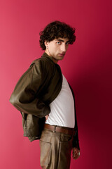 Obraz premium Stylish man poses confidently against a vibrant red wall showcasing modern fashion trends